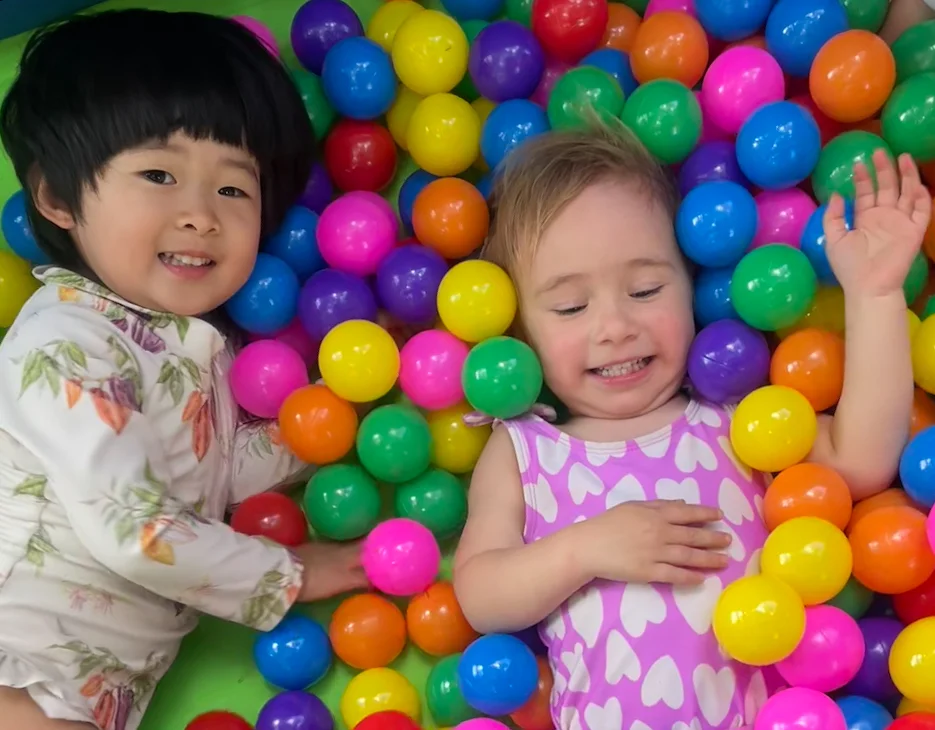 kindergarteners having fun at summer camp ball pit